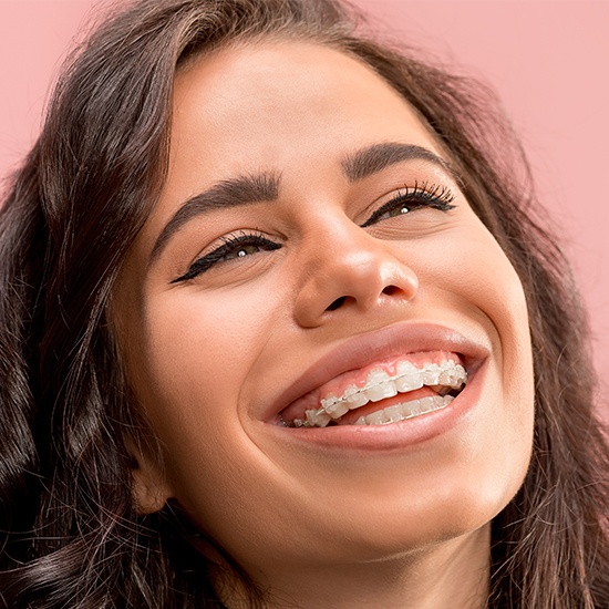 Woman with clear and ceramic bracket and wire braces smiling