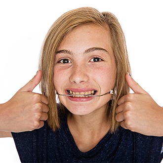 Preteen girl with headgear smiling