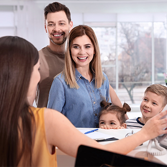 Family checking in at orthodontic office reception desk