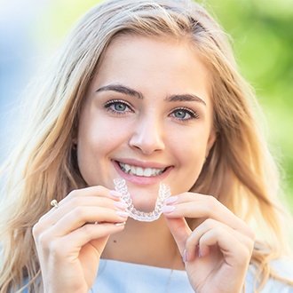 Woman placing Invisalign tray