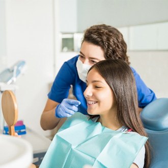 Patient with braces and Holliston orthodontist smiling in handheld mirror