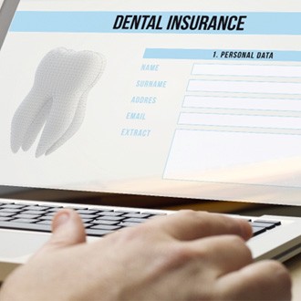 Patient filling out dental insurance paperwork on computer