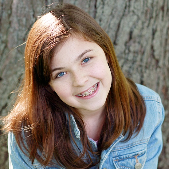 Young girl smiling during pediatric orthodontics treatment