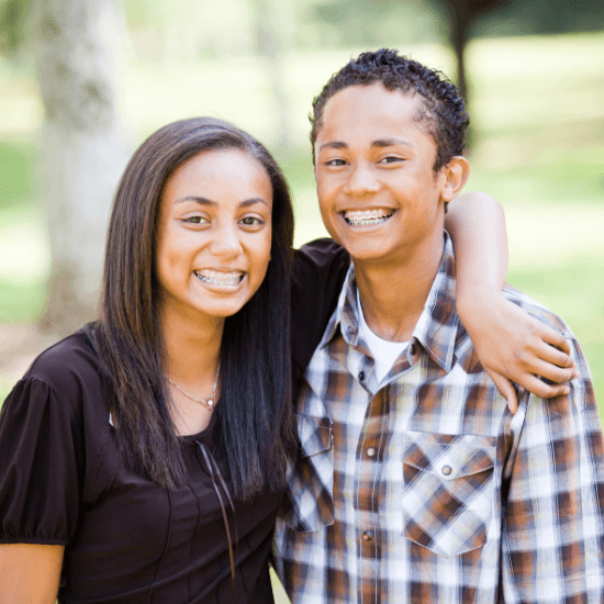 Two smiling teens with braces