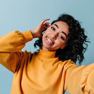 Woman with braces smiling while taking a selfie