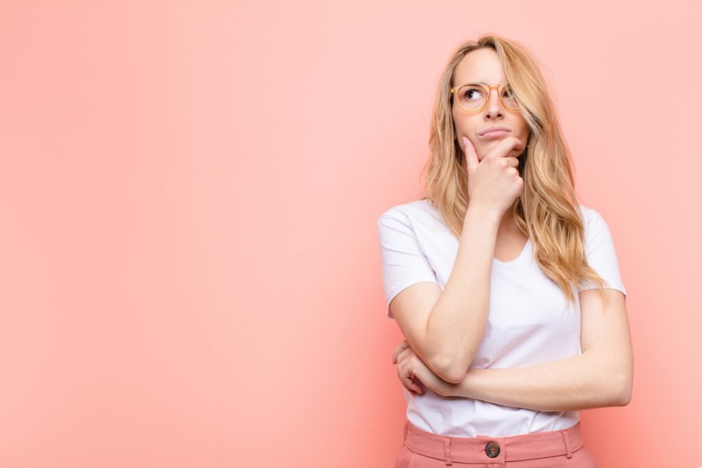 Closeup of woman in white shirt wondering