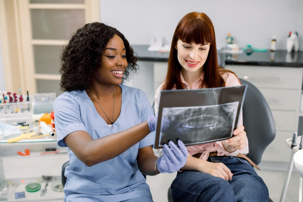 Smiling dental professional showing patient their X-ray