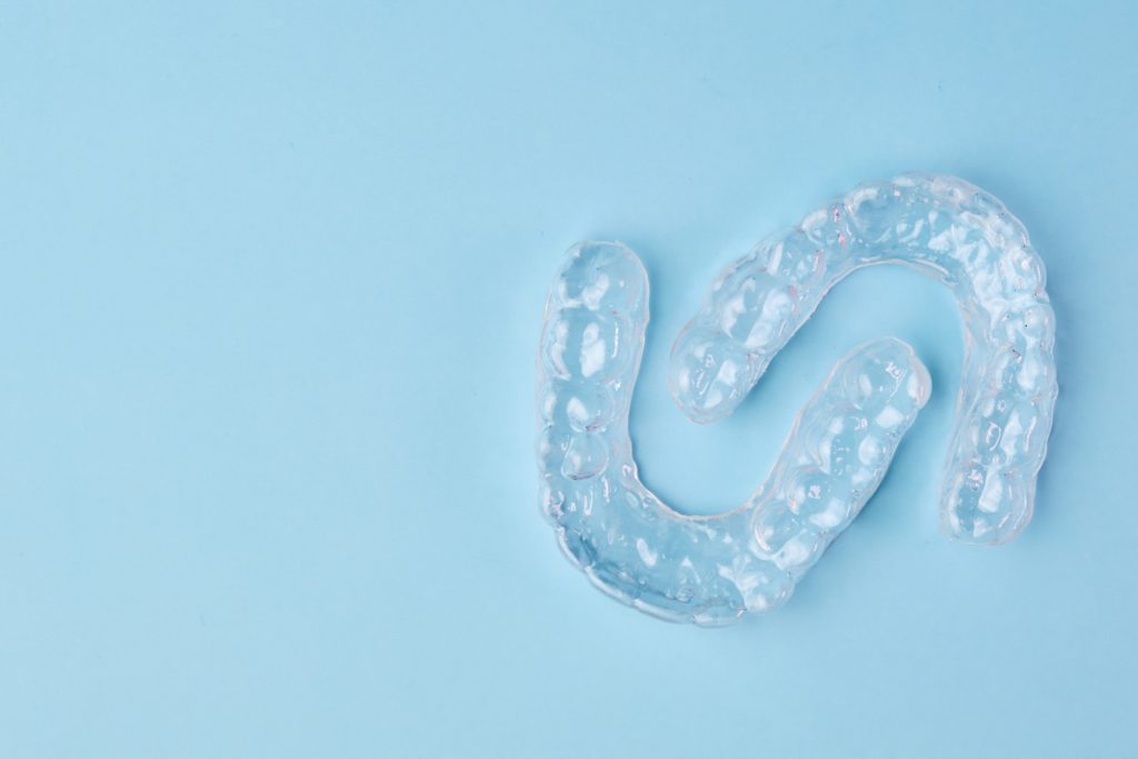 Clear aligners lying on blue desk