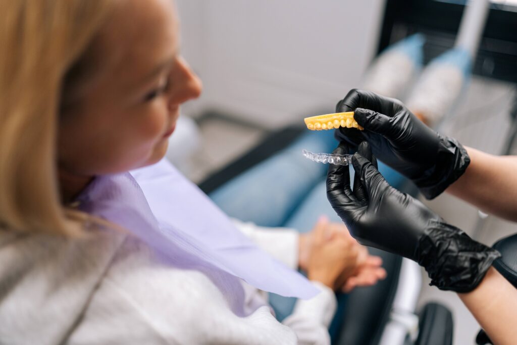 Dentist showing patient clear aligner and mold