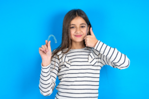 a teen holding their Invisalign aligner